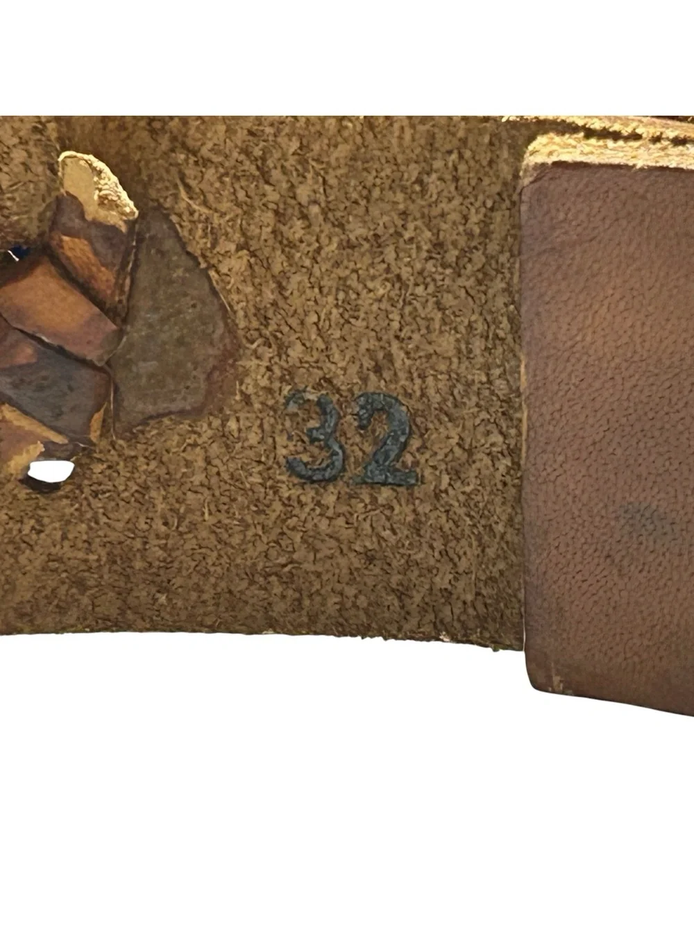 Brown leather belt with X-weave crisscross stitched along the strap.